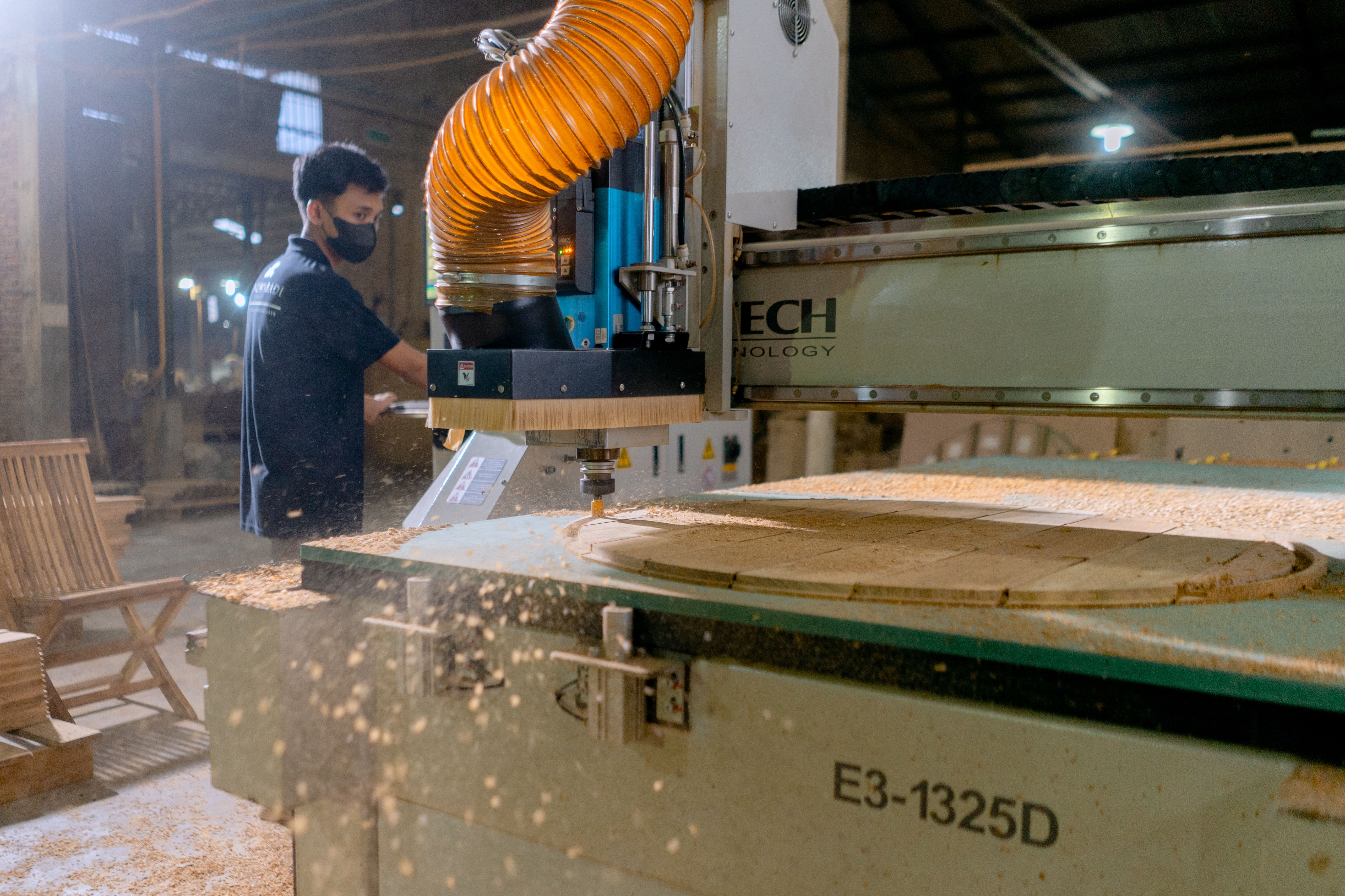 Worker operating a CNC machine in a contemporary woodworking shop