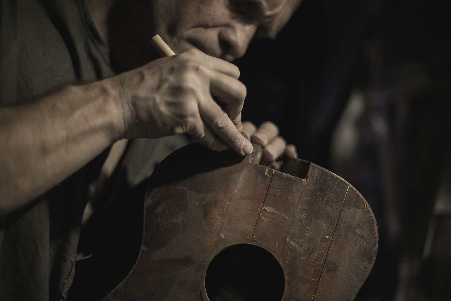 Luthier restoring an acoustic guitar in a workshop