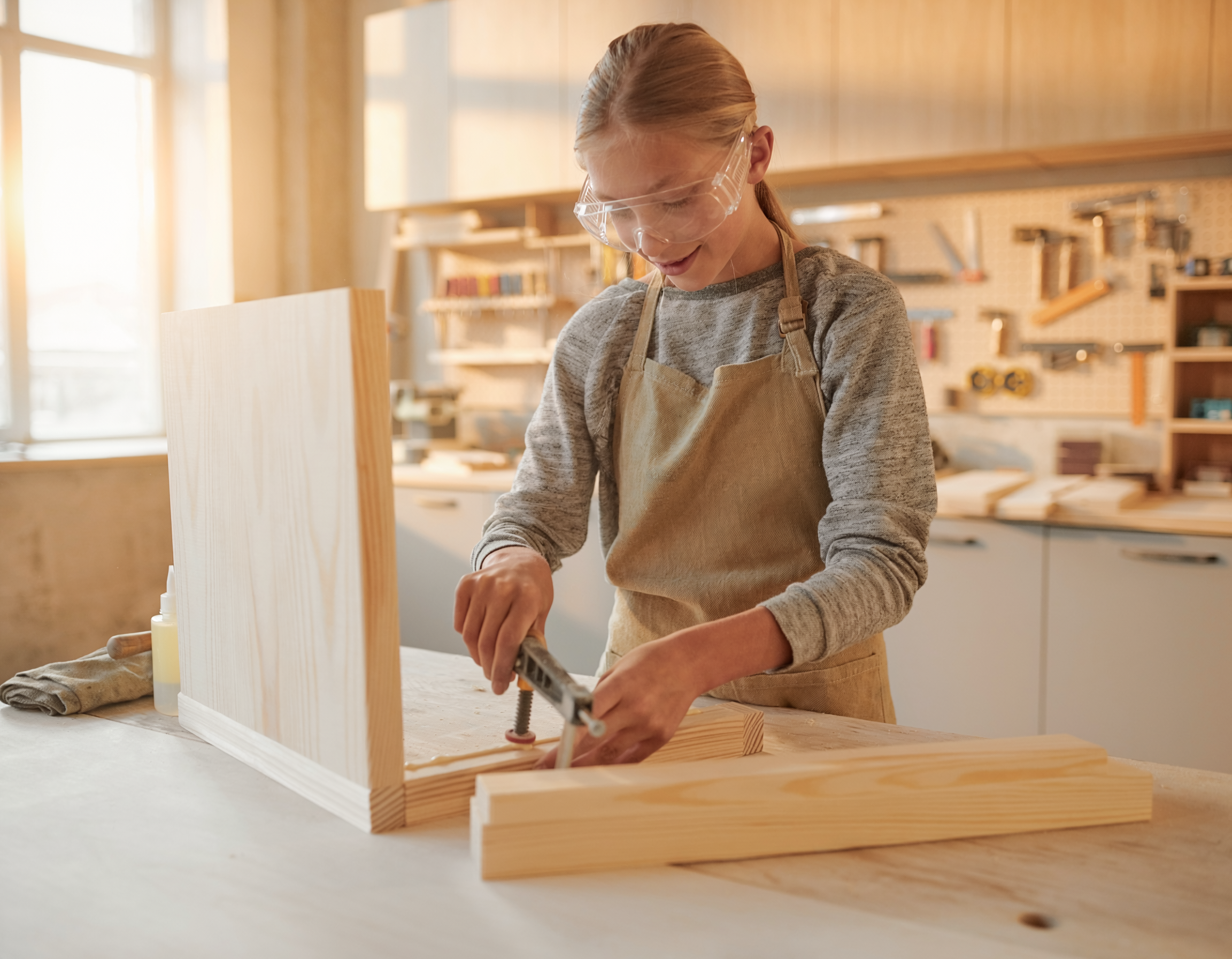 Young maker building a simple wooden project at a bench